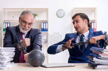 Foto de Los dos empleados masculinos descontentos con el trabajo excesivo - Imagen libre de derechos