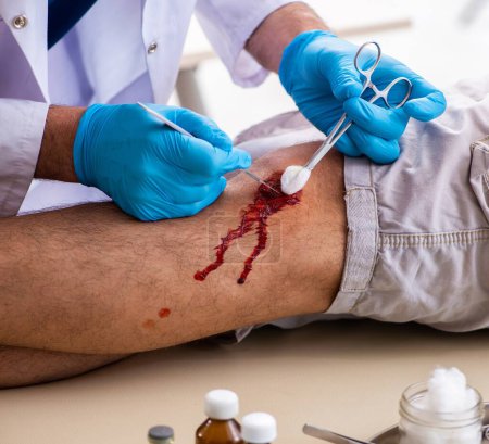 Téléchargez les photos : Jambe blessé médecin visiteur dans le concept de premiers soins - en image libre de droit