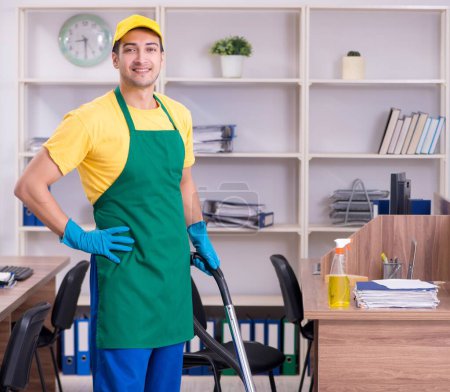Photo for The young male contractor cleaning the office - Royalty Free Image