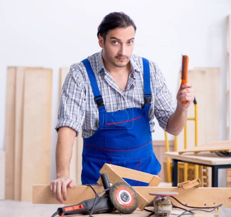 Photo for The young male carpenter working indoors - Royalty Free Image