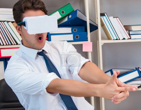 Téléchargez les photos : L'employé qui regarde un film sur vr lunettes de réalité virtuelle - en image libre de droit