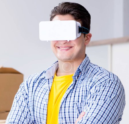 Photo for The young man wearing vr glasses moving in new apartment - Royalty Free Image
