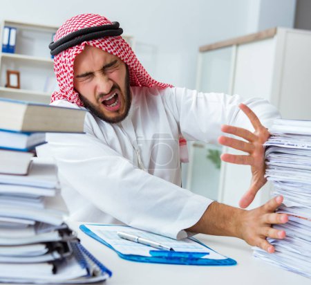 Photo for Arab businessman working in the office doing paperwork with a pile of papers - Royalty Free Image