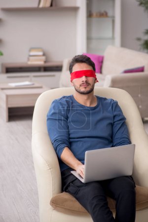 Photo for Blindfolded young freelancer working from home - Royalty Free Image