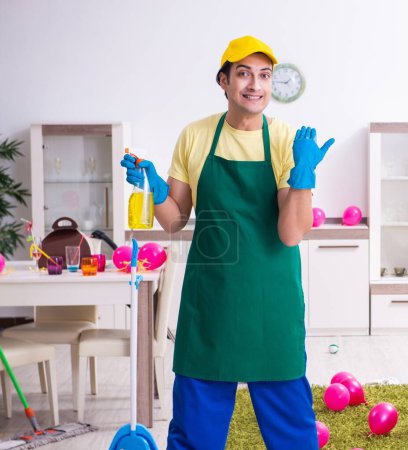 Téléchargez les photos : Le jeune entrepreneur masculin faisant des travaux ménagers après la fête - en image libre de droit