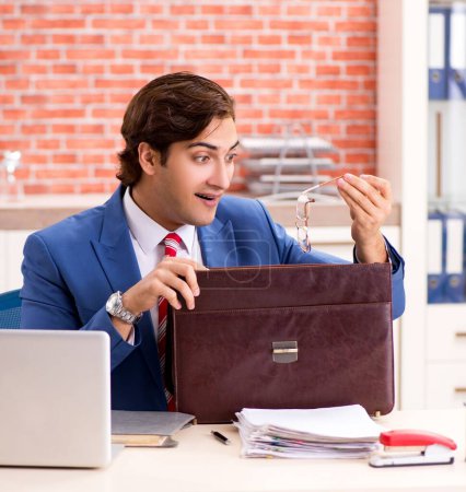 Foto de El joven empleado guapo que trabaja en la oficina - Imagen libre de derechos