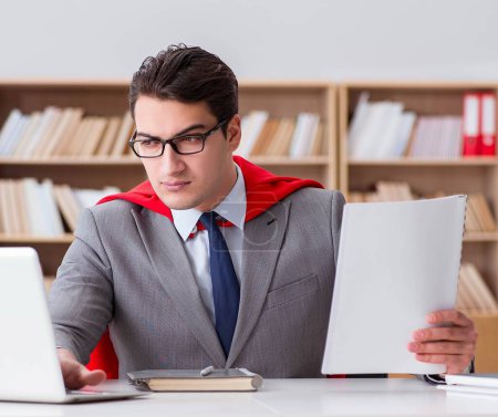 Téléchargez les photos : L'homme d'affaires de super-héros travaillant dans le bureau - en image libre de droit