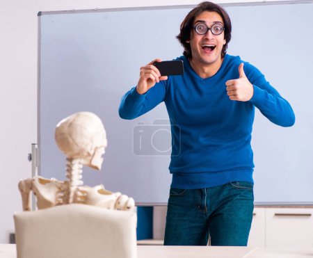 Foto de El profesor masculino y estudiante de esqueleto en el aula - Imagen libre de derechos