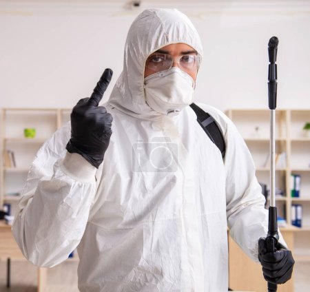Photo for Contractor disinfecting office for the COVID-19 coronavirus - Royalty Free Image