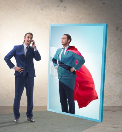 Téléchargez les photos : L'homme d'affaires se voit dans le miroir comme un super-héros - en image libre de droit