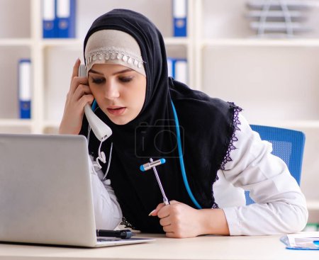 Foto de El joven doctor en hijab que trabaja en la clínica - Imagen libre de derechos