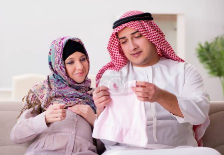 Foto de La joven familia árabe musulmana con esposa embarazada esperando un bebé - Imagen libre de derechos
