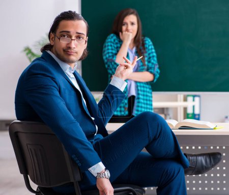 Photo for The young handsome teacher and female student in the classroom - Royalty Free Image