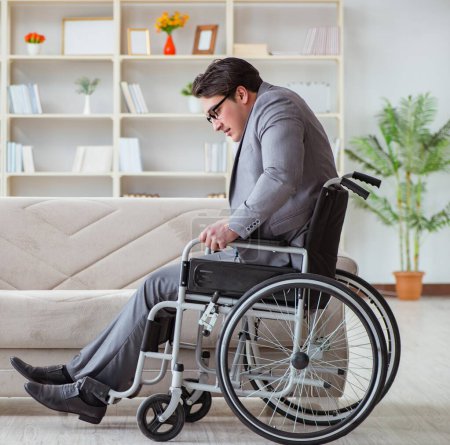 Téléchargez les photos : Homme d'affaires handicapé en fauteuil roulant travaillant à domicile - en image libre de droit