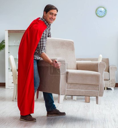 Foto de El súper héroe moviendo muebles en casa - Imagen libre de derechos