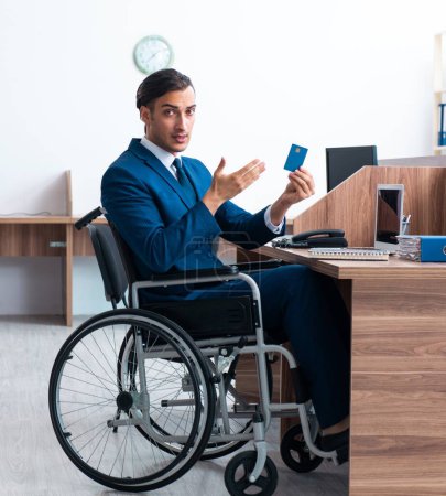 Foto de El joven empleado masculino en silla de ruedas - Imagen libre de derechos