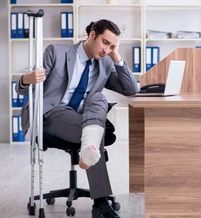 Téléchargez les photos : L'employé masculin blessé à la jambe dans le bureau - en image libre de droit