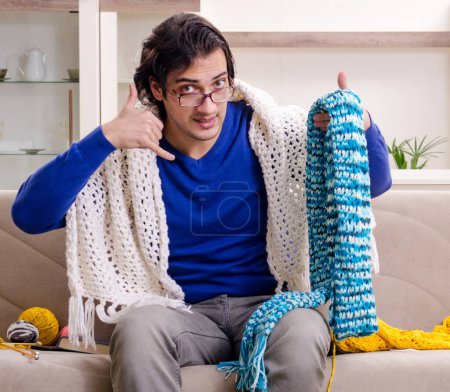 Téléchargez les photos : Le jeune homme beau tricot à la maison - en image libre de droit
