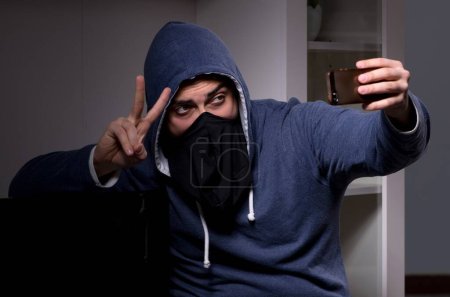 Téléchargez les photos : Le voleur cambrioleur vole la télé de l'immeuble - en image libre de droit