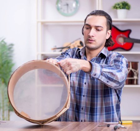 Téléchargez les photos : Le jeune beau réparateur réparateur tambour - en image libre de droit