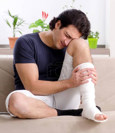 Photo for The leg injured young man suffering at home - Royalty Free Image