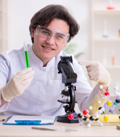Téléchargez les photos : Le jeune biochimiste masculin travaillant dans le laboratoire - en image libre de droit