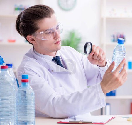 Foto de El joven químico masculino experimentando en el laboratorio - Imagen libre de derechos