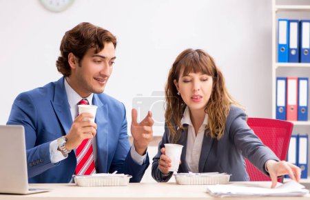 Téléchargez les photos : Les deux collègues en pause déjeuner sur le lieu de travail - en image libre de droit