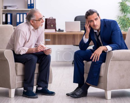 Photo for The young man visiting old male doctor psychologist - Royalty Free Image