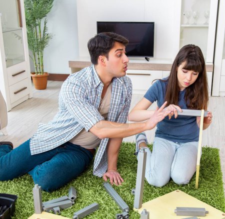 Téléchargez les photos : La jeune famille assemble des meubles dans une nouvelle maison - en image libre de droit