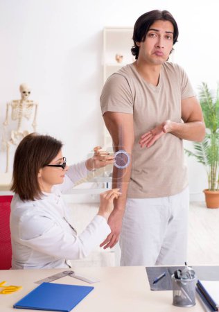 Photo for Female doctor checking patients joint flexibility with goniometer - Royalty Free Image