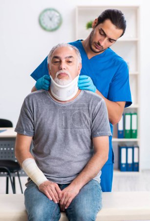 Photo for Young male doctor and old patient in first aid - Royalty Free Image