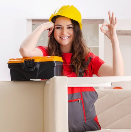 Foto de The female contractor repairing furniture at home - Imagen libre de derechos