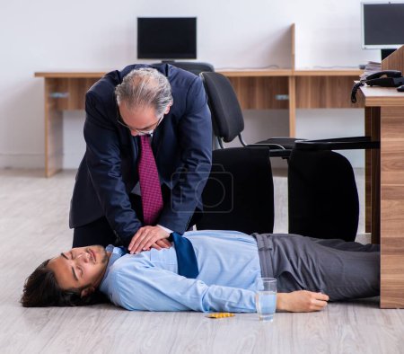 Téléchargez les photos : L'employé masculin souffrant d'une crise cardiaque au bureau - en image libre de droit