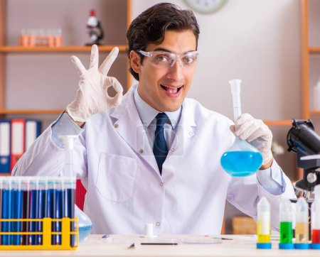 Foto de El joven bioquímico guapo que trabaja en el laboratorio - Imagen libre de derechos