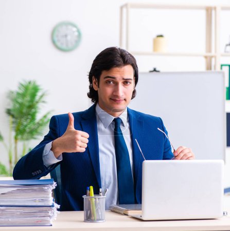 Photo for The young businessman sitting and working in the office - Royalty Free Image