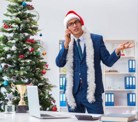 Foto de El hombre de negocios que celebra las vacaciones de Navidad en la oficina - Imagen libre de derechos