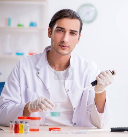 Téléchargez les photos : Le jeune chimiste masculin travaillant dans le laboratoire - en image libre de droit
