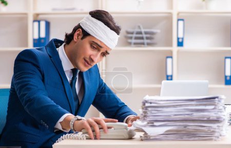 Photo for The head injured male employee working in the office - Royalty Free Image