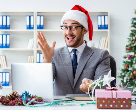 Téléchargez les photos : Le jeune homme d'affaires célébrant Noël au bureau - en image libre de droit