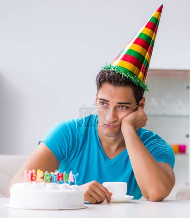Téléchargez les photos : Le jeune homme fête son anniversaire seul à la maison - en image libre de droit