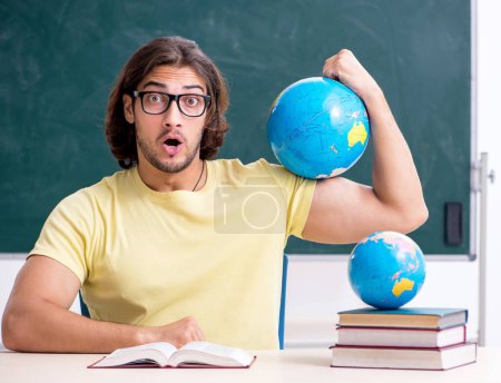 Photo for Young geography teacher in front of blackboard - Royalty Free Image