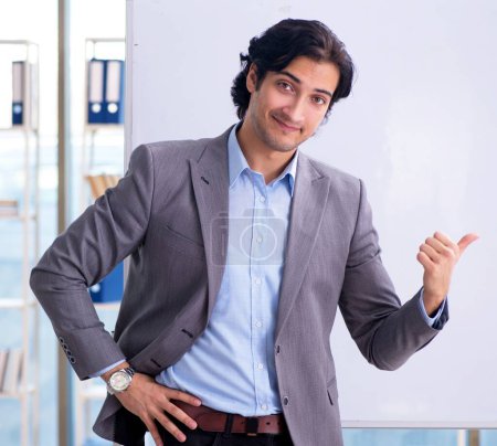 Photo for The young handsome teacher in front of whiteboard - Royalty Free Image