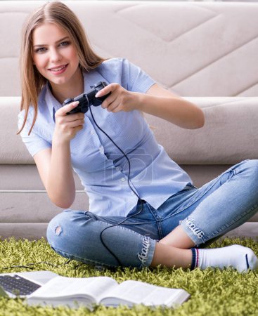 Foto de La joven estudiante jugando juegos en casa - Imagen libre de derechos
