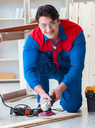 Photo for The young carpenter working with wooden planks - Royalty Free Image