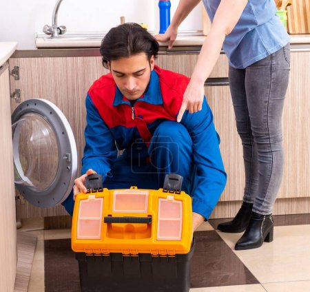 Téléchargez les photos : Le jeune réparateur masculin réparant la machine à laver - en image libre de droit