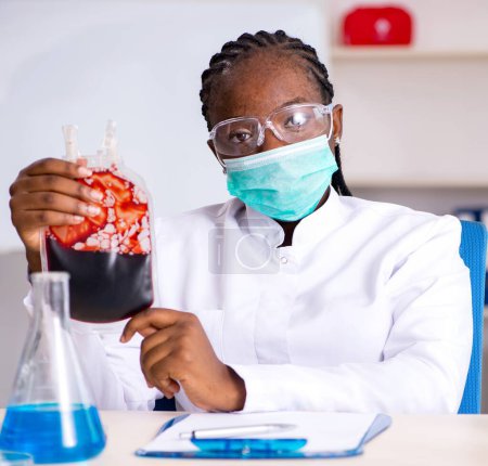 Téléchargez les photos : Le jeune chimiste noir travaillant dans le laboratoire - en image libre de droit