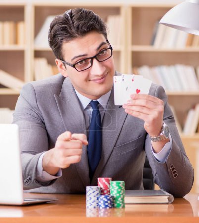 Téléchargez les photos : L'homme d'affaires jouant aux cartes au travail - en image libre de droit