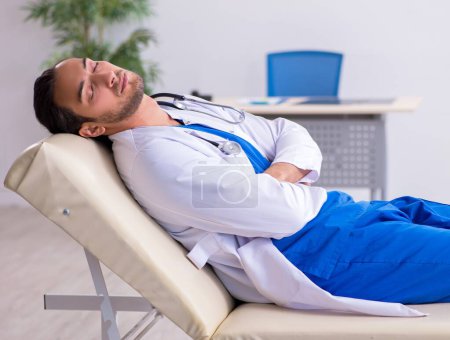 Téléchargez les photos : Jeune médecin fatigué après le quart de nuit - en image libre de droit
