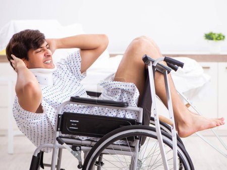 Téléchargez les photos : Le jeune bel homme en fauteuil roulant à l'hôpital - en image libre de droit